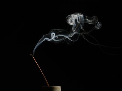 Incense smoke in a minimalist dark room environment